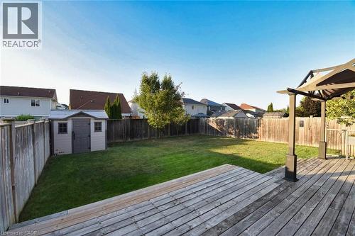 Expansive backyard featuring a large wooden deck, a pergola, a manicured lawn, a storage shed, and full privacy fencing - 188 Hunter Way, Brantford, ON - Outdoor With Deck Patio Veranda