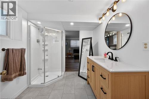 Contemporary bathroom featuring a light wood-finish vanity with a white countertop and rectangular undermount sink - 25 Inverness Avenue, Hamilton, ON 