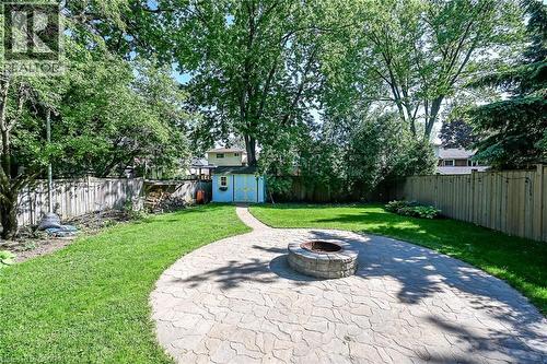 Expansive backyard featuring a curved flagstone patio with an integrated fire pit - 25 Inverness Avenue, Hamilton, ON 