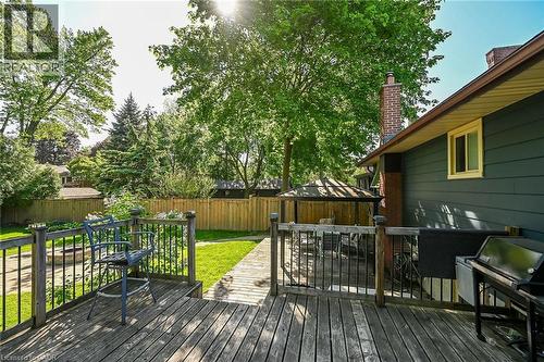Multi-level wood deck featuring black metal railings and a wood-finish pathway - 25 Inverness Avenue, Hamilton, ON 