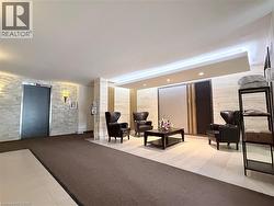 Spacious lobby featuring a seating area with dark wood-finish coffee table, recessed lighting, and wall sconces - 