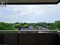 Expansive balcony offering a cityscape and tree-lined neighborhood - 