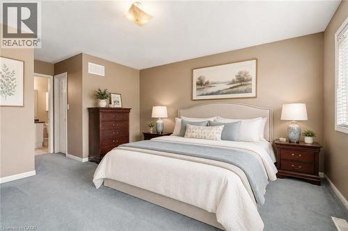 VIRTUALLY STAGED Carpeted room featuring a window with blinds, a ceiling-mounted light fixture, and a doorway leading to another room - 4413 Peter Drive, Burlington, ON 