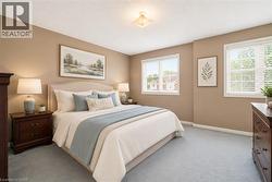 VIRTUALLY STAGED Spacious bedroom with light beige walls and soft blue carpeting - 