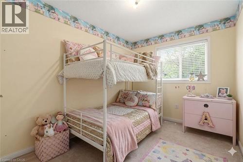 VIRTUALLY STAGED Bright room featuring a window with white blinds, neutral carpeting, and a white bunk bed frame - 4413 Peter Drive, Burlington, ON 