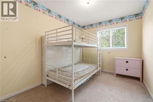 Carpeted room featuring light yellow walls and a large window with blinds - 4413 Peter Drive, Burlington, ON 