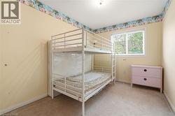 Carpeted room featuring light yellow walls and a large window with blinds - 