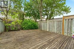 Expansive wood deck with plank construction, surrounded by a wood privacy fence featuring lattice accents - 
