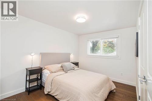 Bright room featuring wood-finish flooring, a white trim window, and neutral wall paint - 39 Forestgate Drive, Hamilton, ON 