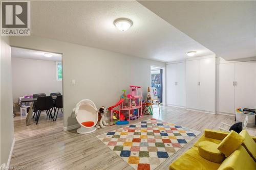 Flexible room featuring wood-finish flooring, recessed lighting, and integrated white cabinetry - 907 Doon Village Road, Kitchener, ON 