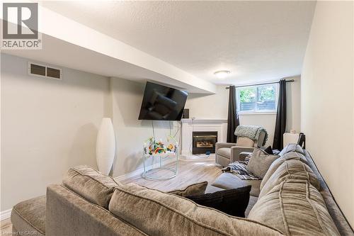Living area featuring recessed lighting, a built-in fireplace with a white mantel, and wood-finish flooring - 907 Doon Village Road, Kitchener, ON 