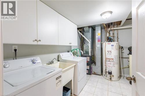Dedicated utility room featuring white cabinetry and a utility sink - 907 Doon Village Road, Kitchener, ON 