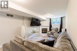 Living area featuring recessed lighting, a built-in fireplace with a white mantel, and wood-finish flooring - 