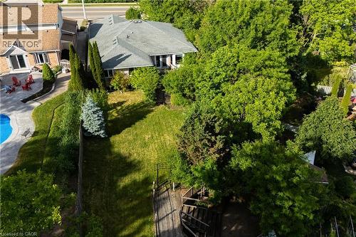 Rear exterior featuring a large lawn, mature trees and landscaping, and a multi-level deck with stairs - 907 Doon Village Road, Kitchener, ON - Outdoor