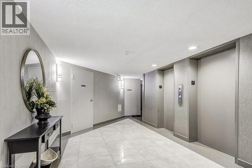 Hallway with light-toned tiled flooring and textured wall coverings - 1201 North Shore Boulevard E Unit# 706, Burlington, ON - Indoor Photo Showing Other Room