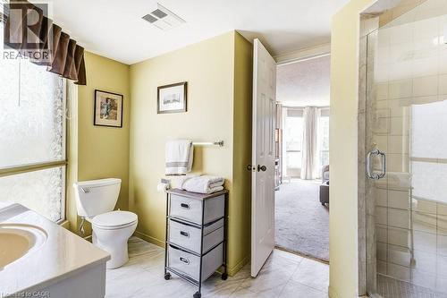 Bathroom featuring a vanity with an integrated sink, a toilet, and a tiled shower enclosure with a glass door - 1201 North Shore Boulevard E Unit# 706, Burlington, ON - Indoor Photo Showing Bathroom