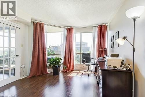 Room featuring dark wood-finish flooring and floor-to-ceiling windows with red drapery - 1201 North Shore Boulevard E Unit# 706, Burlington, ON - Indoor