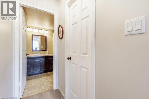 Bathroom vanity featuring a dark wood-finish cabinet with silver-toned hardware, a white countertop, and a rectangular undermount sink with a chrome faucet - 1201 North Shore Boulevard E Unit# 706, Burlington, ON - Indoor Photo Showing Other Room