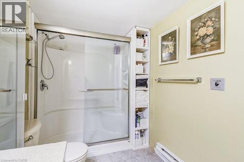 White shower enclosure with a sliding glass door and integrated showerhead - 1201 North Shore Boulevard E Unit# 706, Burlington, ON - Indoor Photo Showing Bathroom