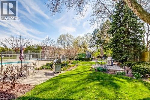 Spacious outdoor area featuring a swimming pool, paved patio, and manicured lawn - 1201 North Shore Boulevard E Unit# 706, Burlington, ON - Outdoor