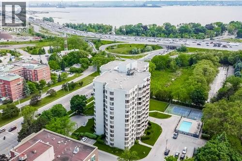 High-rise building with multiple balconies, surrounded by green landscaping - 1201 North Shore Boulevard E Unit# 706, Burlington, ON - Outdoor With View