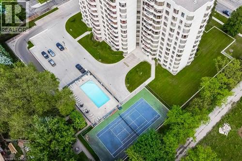 High-rise residential building featuring multiple balconies, a tennis court, and an outdoor swimming pool - 1201 North Shore Boulevard E Unit# 706, Burlington, ON - Outdoor With View
