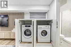Integrated laundry appliances within custom white cabinetry - 