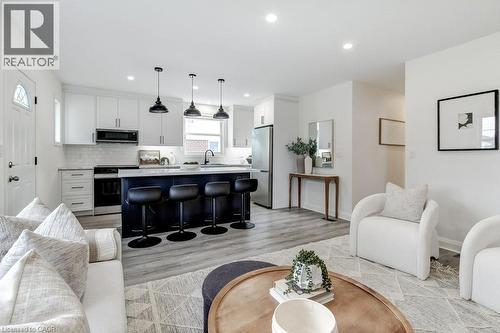 Open-concept living space featuring wood-finish flooring, recessed lighting, and a kitchen island with seating - 202 Erindale Avenue, Hamilton, ON 