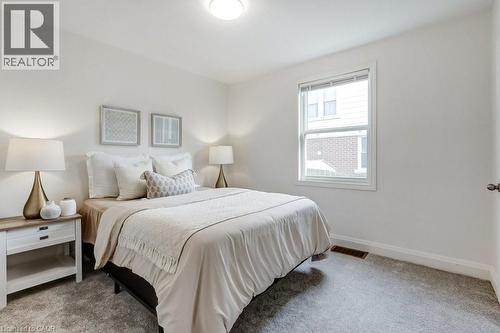 Carpeted bedroom featuring white walls, a single window with blinds, and an overhead flush-mount light fixture - 202 Erindale Avenue, Hamilton, ON 