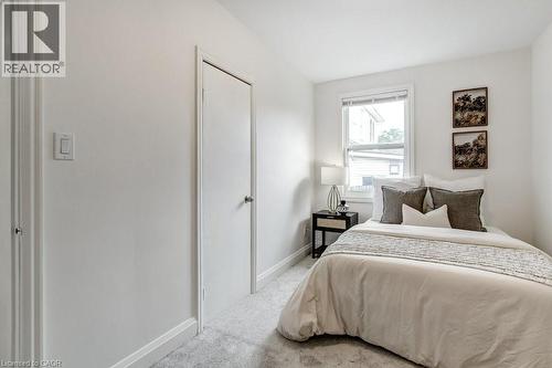Carpeted room with white walls and trim, featuring a double-hung window with blinds - 202 Erindale Avenue, Hamilton, ON 