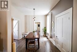 Spacious interior featuring wood-finish flooring, tall ceilings, and a modern pendant light fixture - 