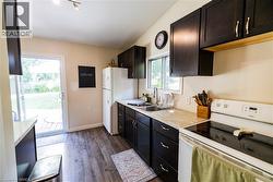 Kitchen featuring dark wood cabinetry, light-toned countertops, and wood-finish flooring - 