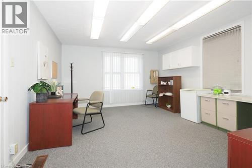 Spacious room featuring light gray wall paint, gray carpeting, and multiple windows - 731 King Street E, Cambridge, ON 