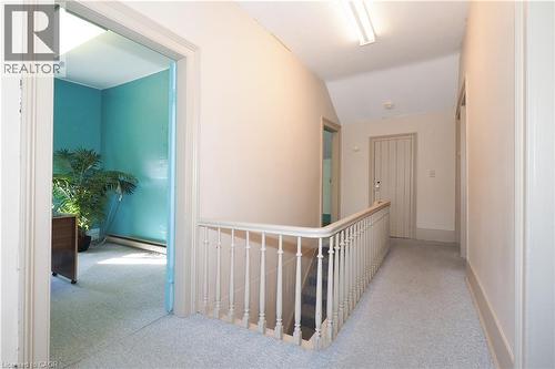 Carpeted hallway with a traditional balustrade and recessed lighting - 731 King Street E, Cambridge, ON 