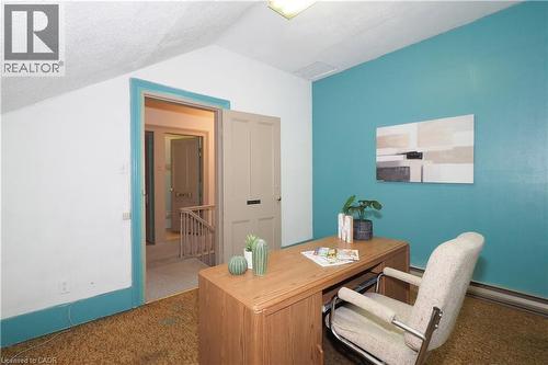 Sloped ceiling room featuring a teal accent wall and neutral carpeting - 731 King Street E, Cambridge, ON 