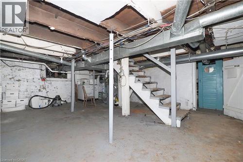 Unfinished basement featuring concrete flooring, exposed ceiling joists, and a partial staircase - 731 King Street E, Cambridge, ON 