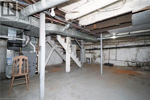 Unfinished basement space featuring exposed ceiling joists, concrete flooring, utility sink, and visible HVAC ductwork - 731 King Street E, Cambridge, ON 