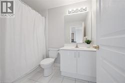 Bathroom featuring a white vanity with a countertop, undermount sink, and polished chrome faucet - 