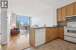 Kitchen featuring wood-finish cabinetry, dark countertops, and tile backsplash - 