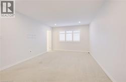 Empty room with light carpet and recessed lighting - 