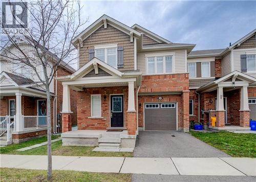 Craftsman-style home with a porch, brick siding, driveway, an attached garage, and a front lawn - 302 Jean Landing, Milton, ON 