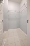 Walk in closet featuring light tile patterned floors - 