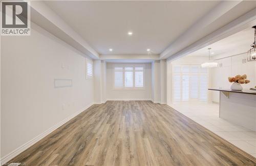 Unfurnished living room with light wood finished floors, a raised ceiling, and recessed lighting - 302 Jean Landing, Milton, ON 