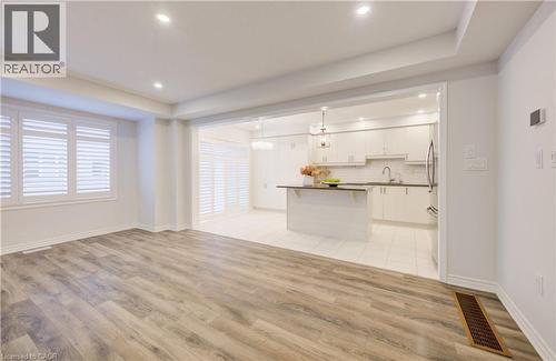 Unfurnished living room with light wood-type flooring, recessed lighting, and a raised ceiling - 302 Jean Landing, Milton, ON 