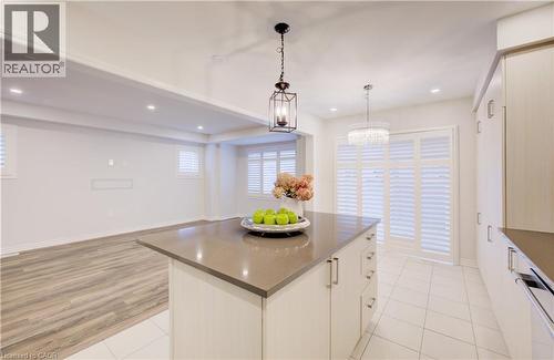 Kitchen with a kitchen island, white cabinets, hanging light fixtures, open floor plan, and dishwasher - 302 Jean Landing, Milton, ON 