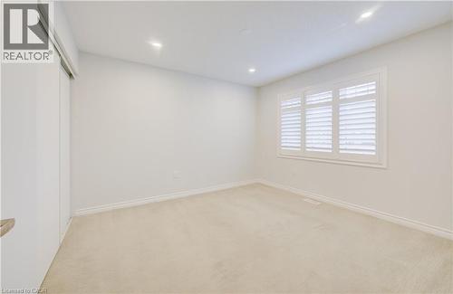 Unfurnished bedroom with light carpet, recessed lighting, and a closet - 302 Jean Landing, Milton, ON 