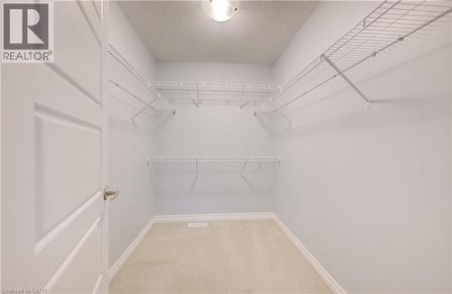 Walk in closet featuring light carpet - 302 Jean Landing, Milton, ON 