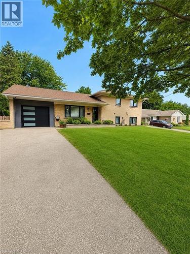 Brick exterior with a modern garage door - 33 Tyrell Street, Simcoe, ON - Outdoor With Facade