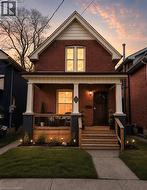 Brick exterior featuring an inviting front porch with white columns - 