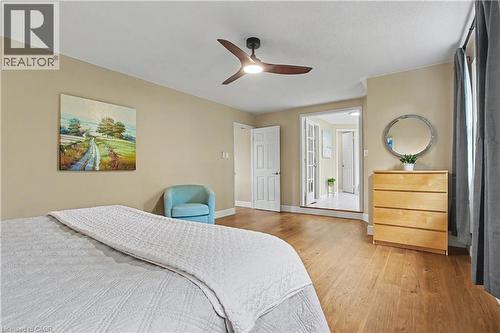 Spacious room featuring wood-finish flooring, a modern ceiling fan with lighting, and neutral wall tones - 4237 Millcroft Park Drive, Burlington, ON 